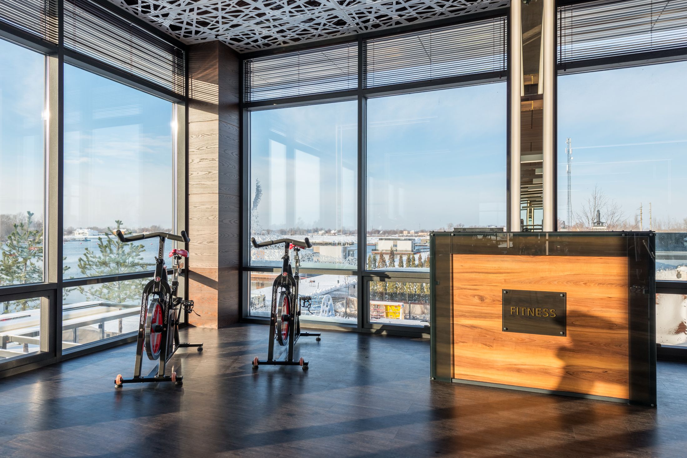 Gym reception desk beside spin bikes and large windows